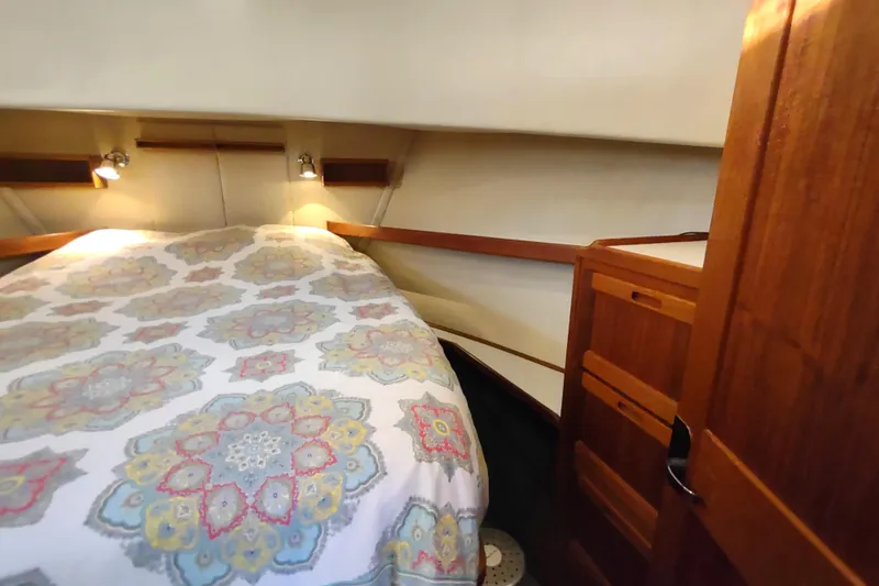 Green Goose Yacht Photos Pics Cozy cabin interior of 1998 Nordic Tug 42 with patterned bedding and wooden cabinetry.