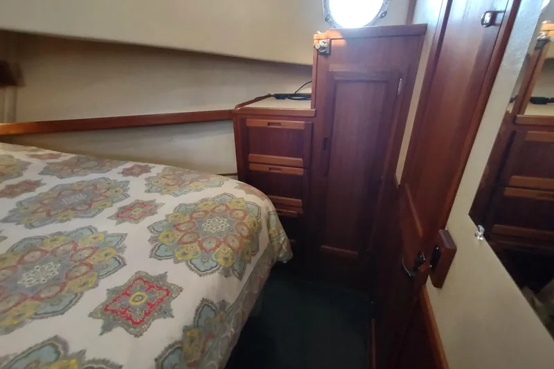 Green Goose Yacht Photos Pics Cozy cabin interior of 1998 Nordic Tug 42 with patterned bedding and wooden cabinetry.