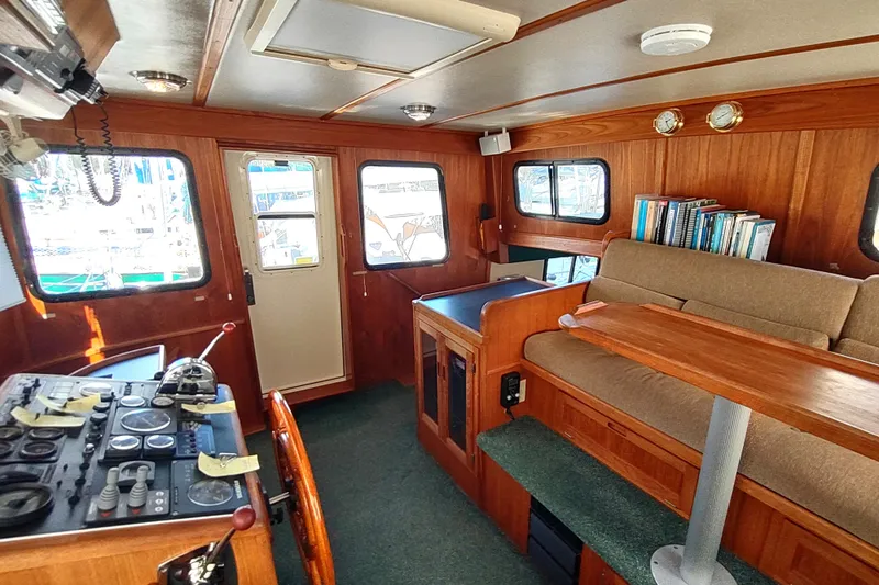 Green Goose Yacht Photos Pics Cozy interior of 1998 Nordic Tug 42 with wooden accents and navigation controls.