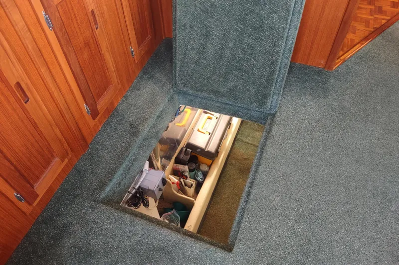 Green Goose Yacht Photos Pics Carpeted floor hatch open, revealing storage space in 1998 Nordic Tug 42 boat interior.