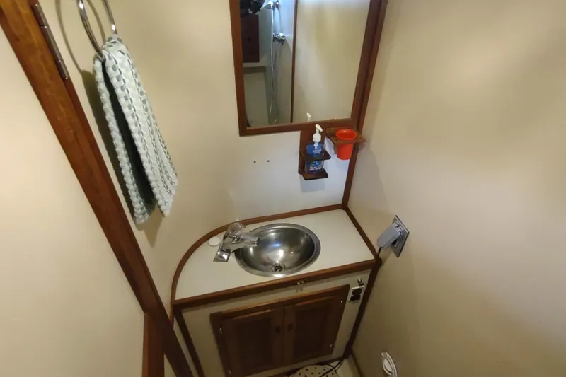 Green Goose Yacht Photos Pics Bathroom interior of 1998 Nordic Tug 42 with sink, mirror, and towel.
