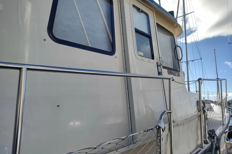 Green Goose Yacht Photos Pics 1998 Nordic Tug 42 boat side view with railing and windows.