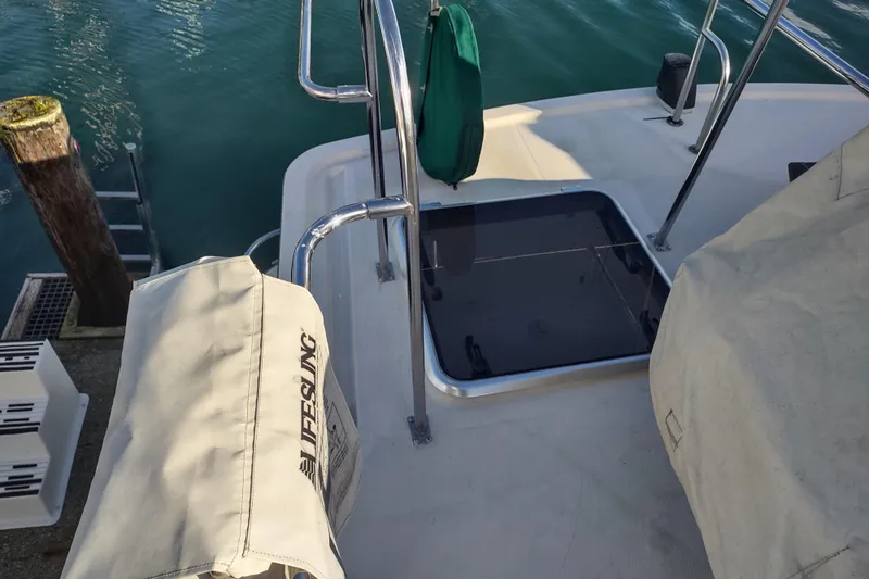 Green Goose Yacht Photos Pics 1998 Nordic Tug 42 deck with railing, hatch, and covered equipment at dockside.