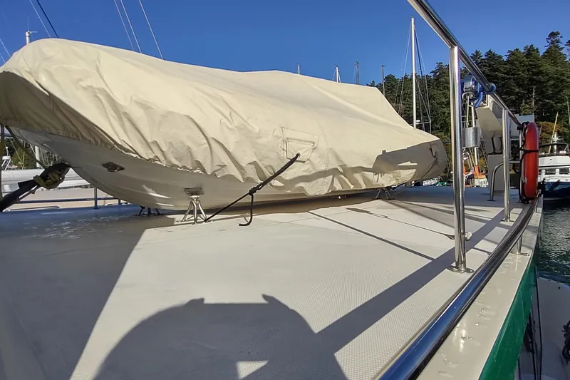 Green Goose Yacht Photos Pics 1998 Nordic Tug 42 with covered dinghy on deck, docked in a marina.