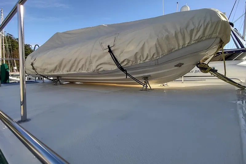 Green Goose Yacht Photos Pics Covered dinghy on deck of 1998 Nordic Tug 42 boat under clear sky.