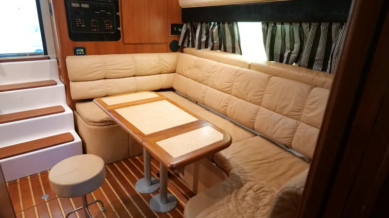 Extremely Clean Boat Yacht Photos Pics Interior of 2000 Tiara Yachts 3700 Open with beige seating and wooden table.