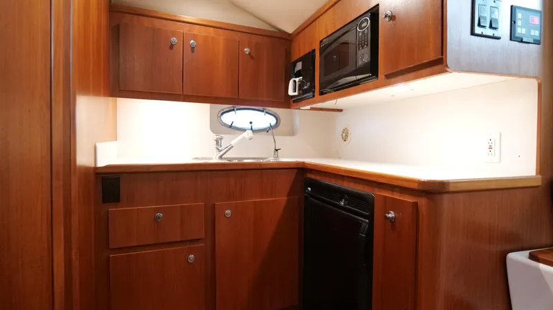 Extremely Clean Boat Yacht Photos Pics 2000 Tiara Yachts 3700 Open galley with wood cabinetry, microwave, and sink.