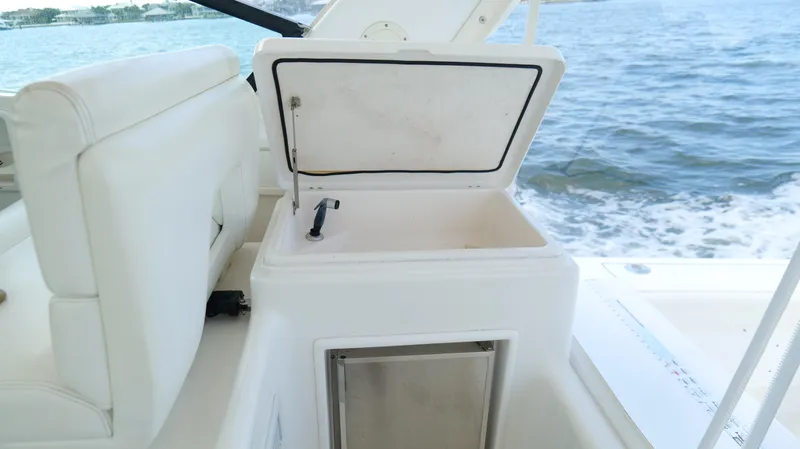 Extremely Clean Boat Yacht Photos Pics 2000 Tiara Yachts 3700 Open boat interior with open storage compartment, white seating, and ocean view.