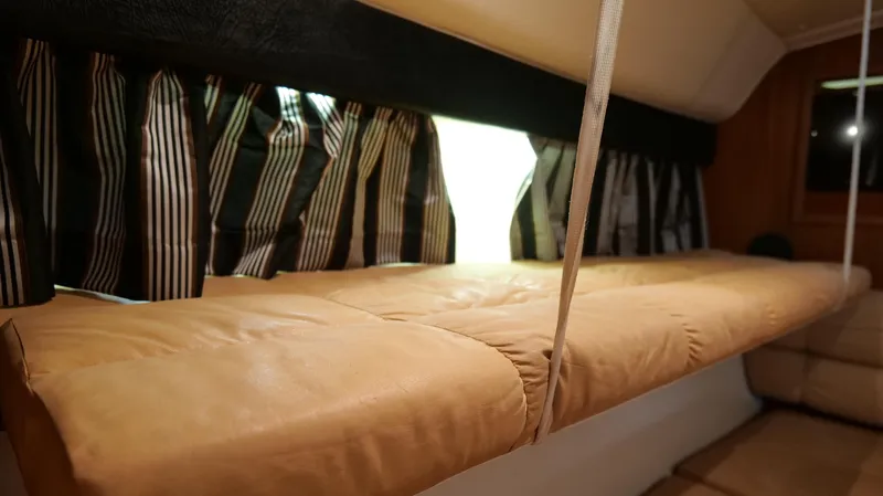 Extremely Clean Boat Yacht Photos Pics Interior cabin of 2000 Tiara Yachts 3700 Open with striped curtains and cushioned seating.