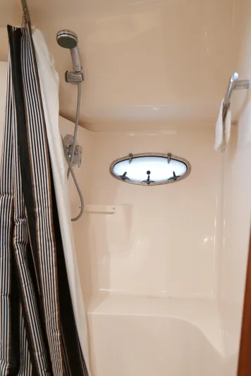 Extremely Clean Boat Yacht Photos Pics Shower area in 2000 Tiara Yachts 3700 Open, featuring striped curtain and porthole window.