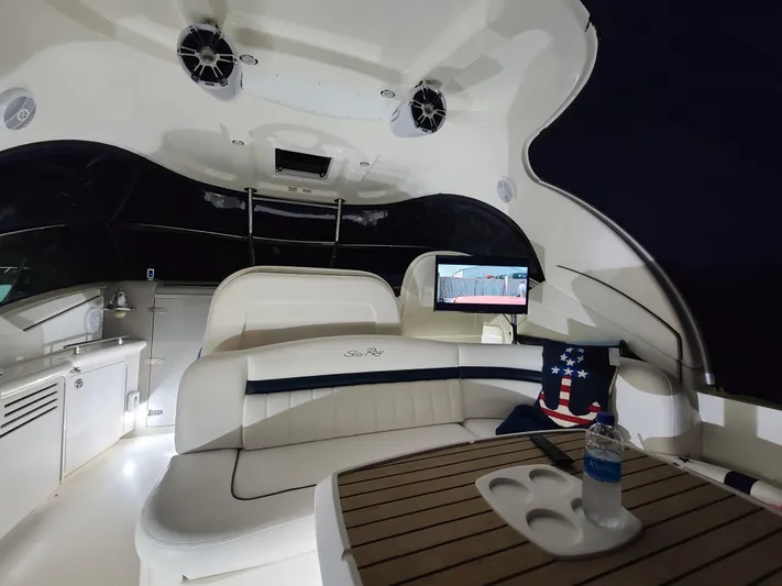 Freedom Yacht Photos Pics 2004 Sea Ray 390 Sundancer interior with seating, table, and entertainment system at night.