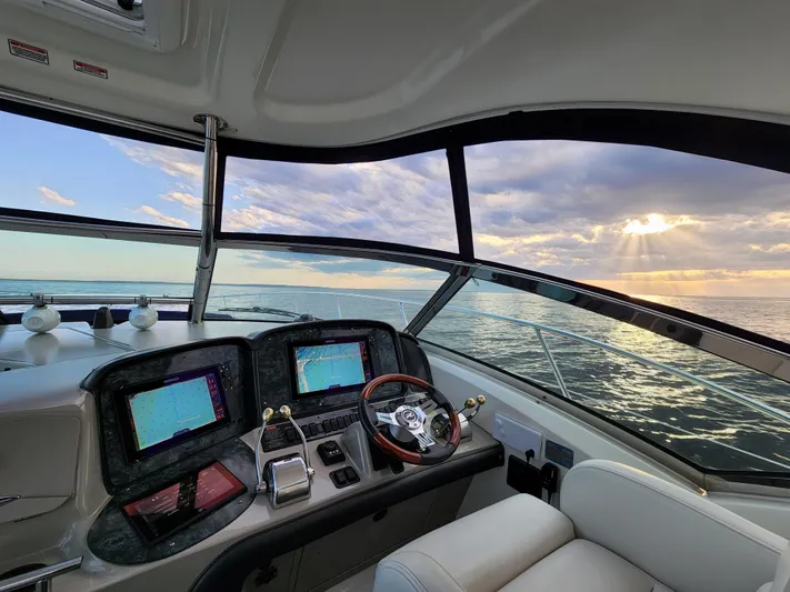 Freedom Yacht Photos Pics Cockpit view of 2004 Sea Ray 390 Sundancer yacht at sunset on the ocean.