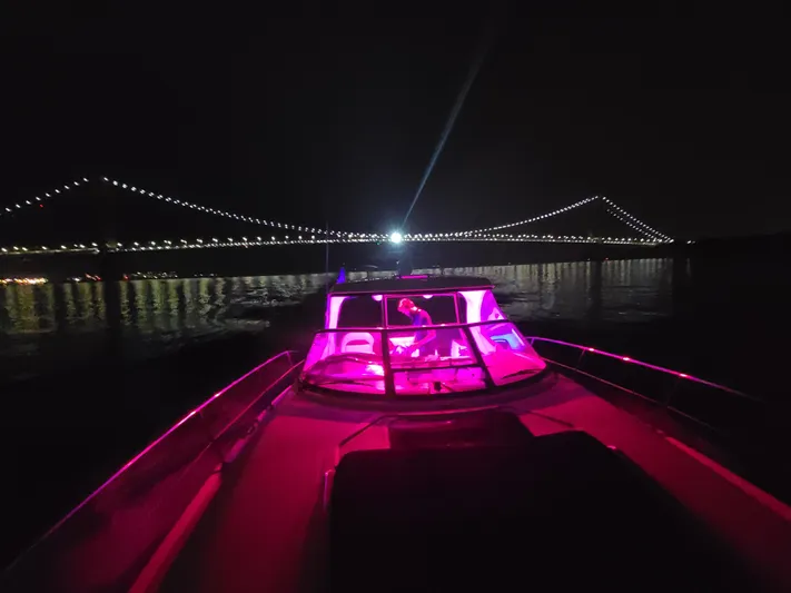Freedom Yacht Photos Pics 2004 Sea Ray 390 Sundancer with pink lights, under illuminated bridge at night.