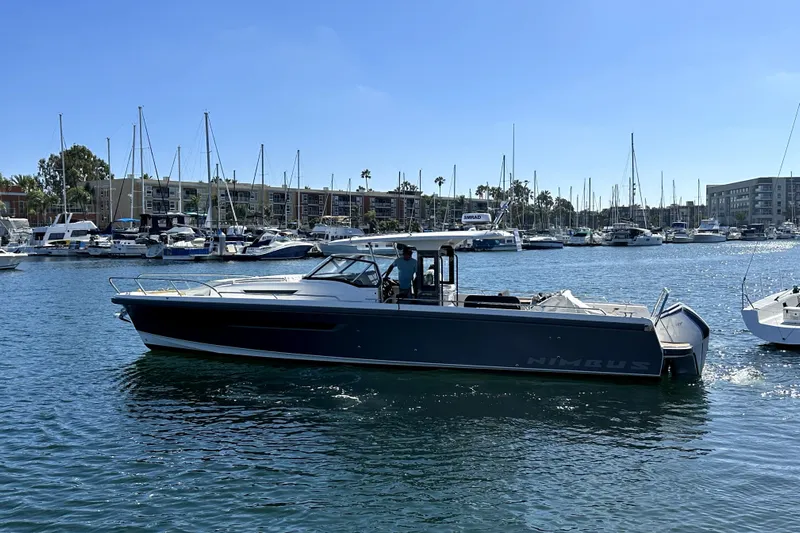 Mdr #187 In Stock Yacht Photos Pics 2023 Nimbus T11 boat cruising in a marina with sailboats in the background.