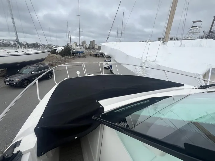  Yacht Photos Pics 2023 Sea Ray Sundancer 320 yacht with black cover, docked in a marina.