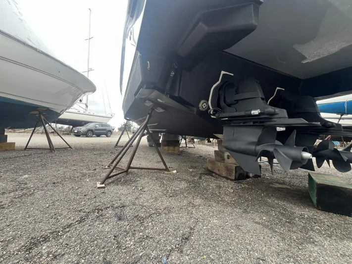  Yacht Photos Pics 2023 Sea Ray Sundancer 320 boat on stands, showcasing propellers and hull.