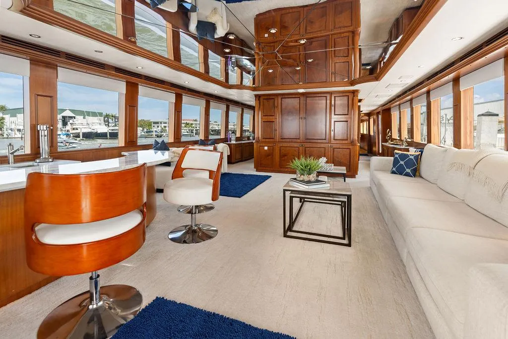 Luxurious interior of 2004 Hatteras 100 Motor Yacht with elegant wood paneling and modern furnishings.