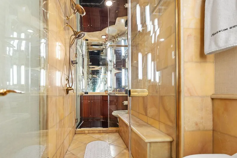 Magnum Ride Yacht Photos Pics Luxurious bathroom in 2004 Hatteras 100 Motor Yacht with glass shower and elegant fixtures.
