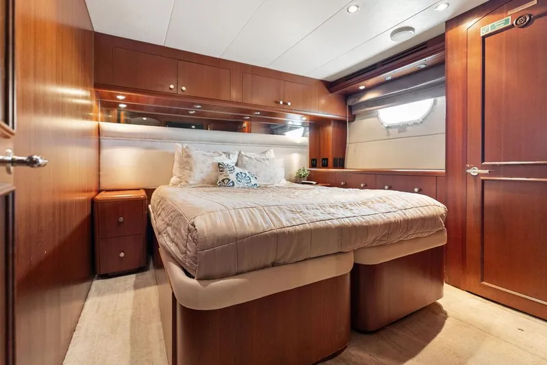 Magnum Ride Yacht Photos Pics Luxurious bedroom interior of 2004 Hatteras 100 Motor Yacht with wood paneling.