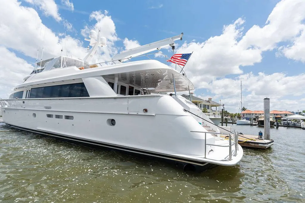 2004 Hatteras 100 Motor Yacht docked, featuring sleek design and American flag.