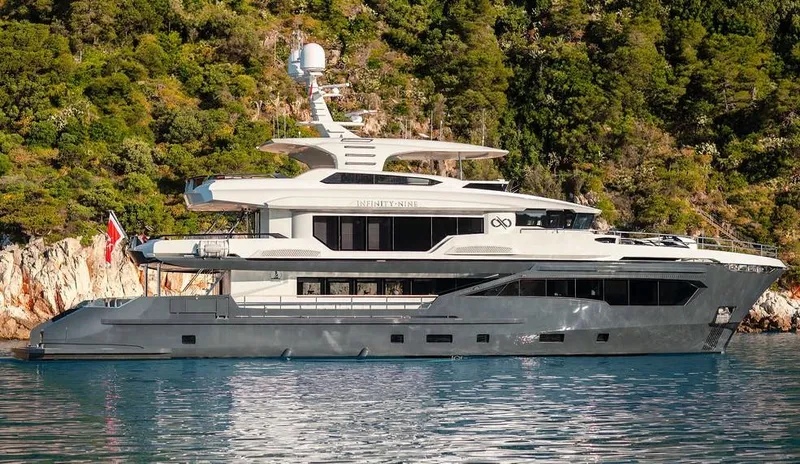 Infinity Nine Yacht Photos Pics Luxurious 2022 AvA Yachts Kando yacht docked by lush green cliffs.