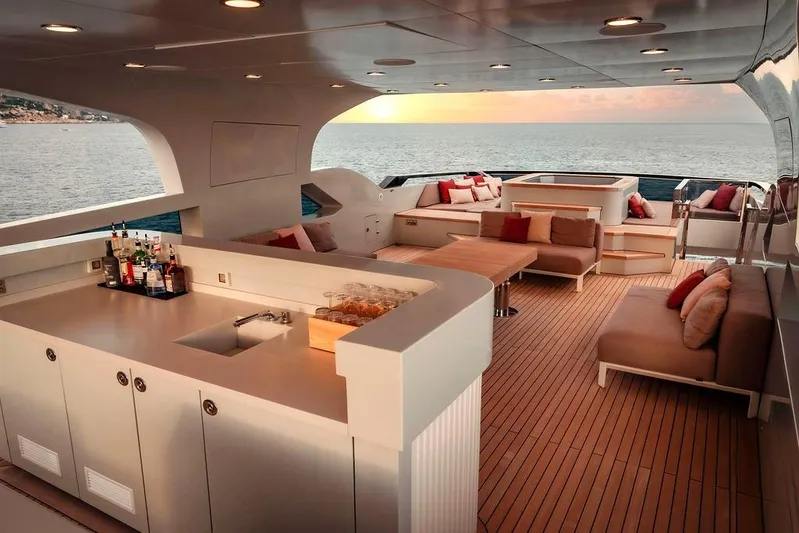 Infinity Nine Yacht Photos Pics Luxurious 2022 AvA Yachts Kando deck with elegant seating and ocean view at sunset.