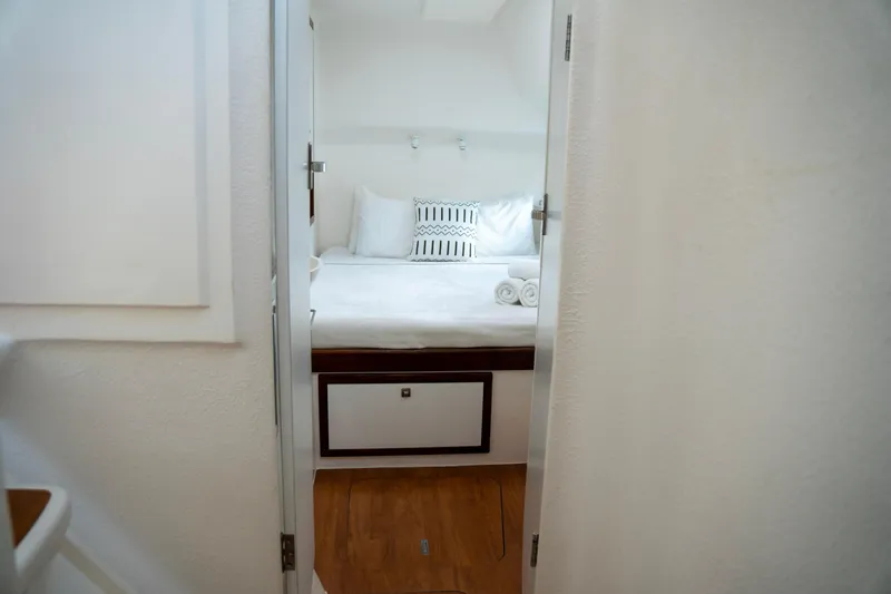  Yacht Photos Pics Cozy bedroom interior on 2017 Voyage Yachts VOYAGE 480, featuring white bedding and wooden flooring.