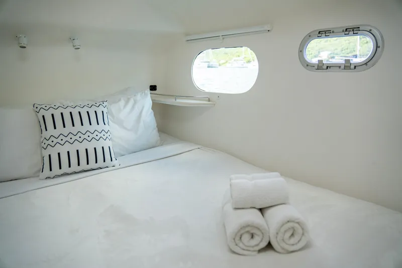  Yacht Photos Pics Cozy cabin interior of 2017 Voyage Yachts VOYAGE 480 with bed and porthole window.