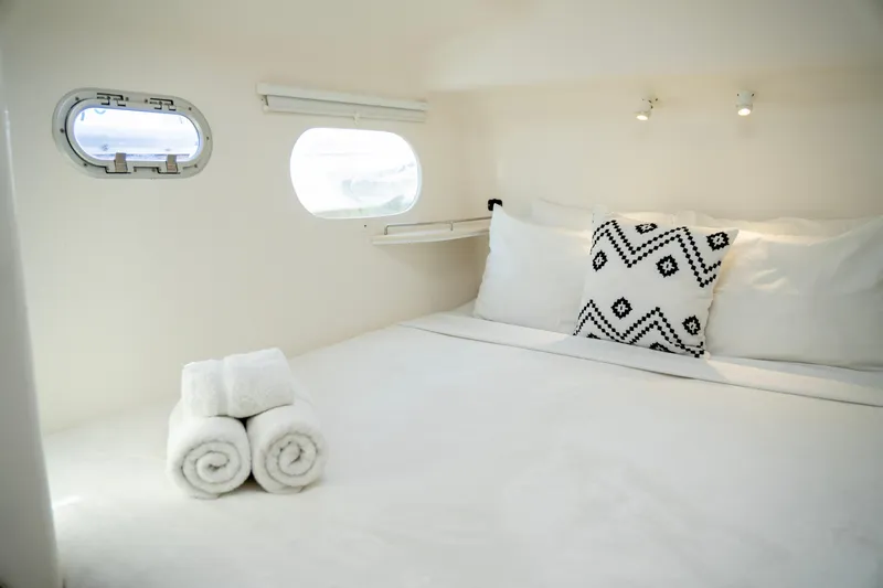  Yacht Photos Pics Luxurious cabin interior of 2017 Voyage Yachts VOYAGE 480 with plush bedding and porthole windows.