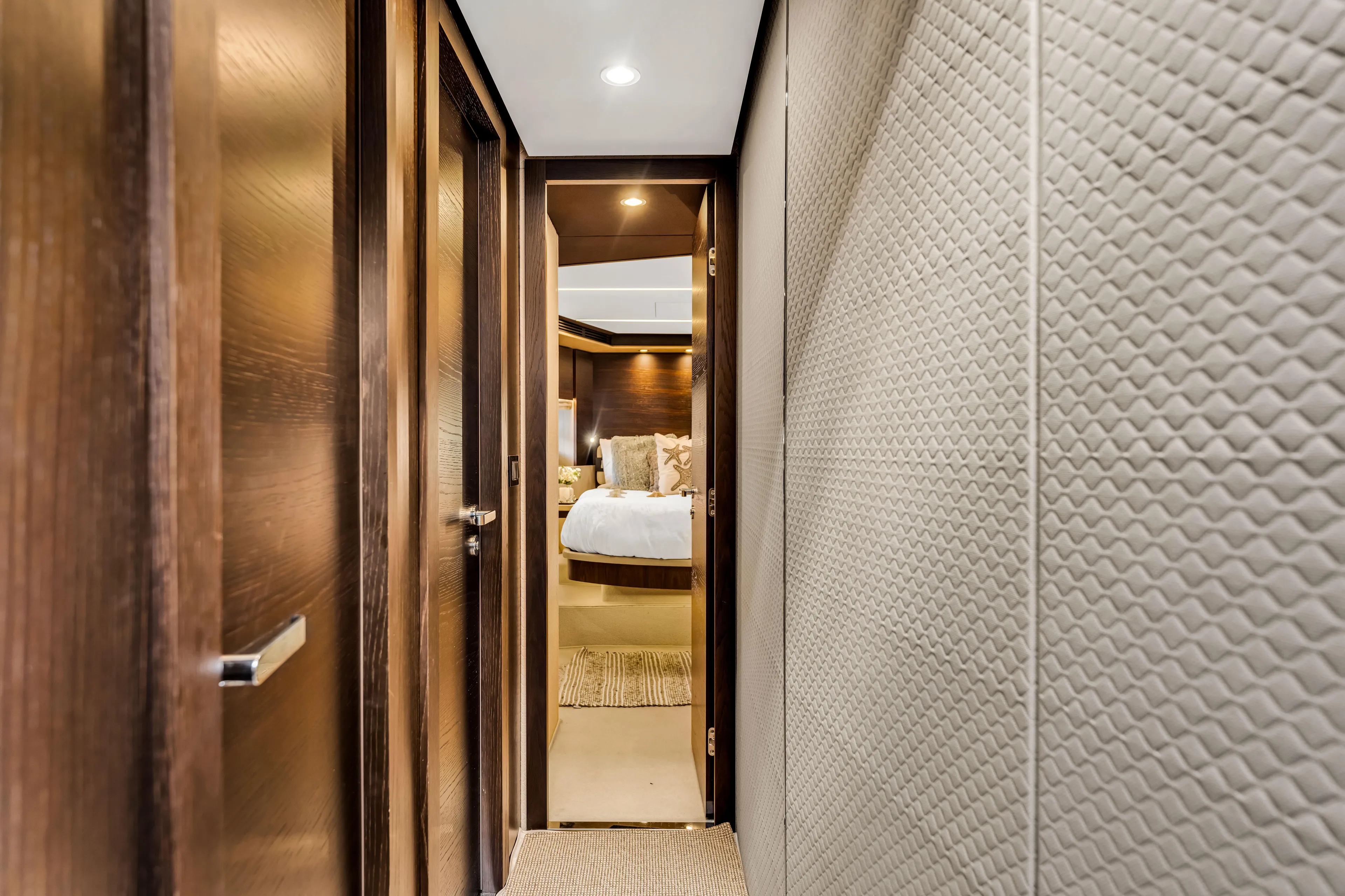 Mancusa Yacht Photos Pics Luxurious interior hallway of 2016 Azimut Fly 72 yacht, leading to a cozy bedroom.