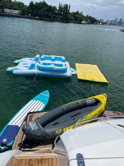 Mancusa Yacht Photos Pics Azimut Fly 72 yacht with paddleboard, inflatable raft, and floating mat on water.