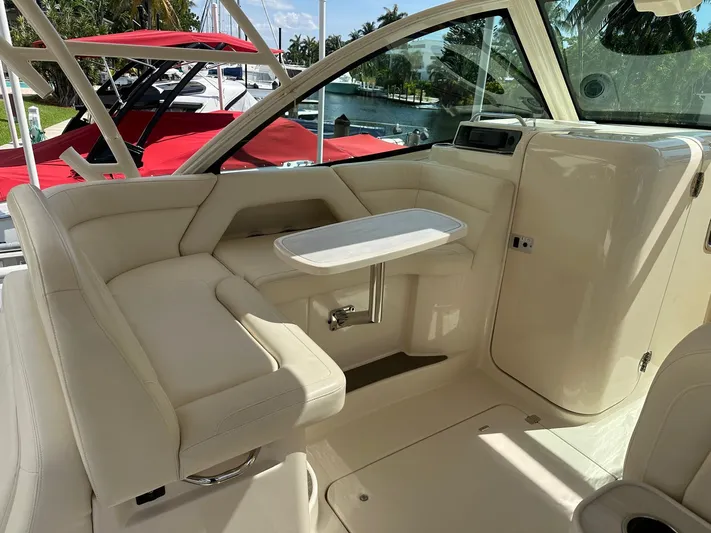 V5 Yacht Photos Pics 2019 Grady-White Freedom 375 boat interior with seating and table, docked by the water.