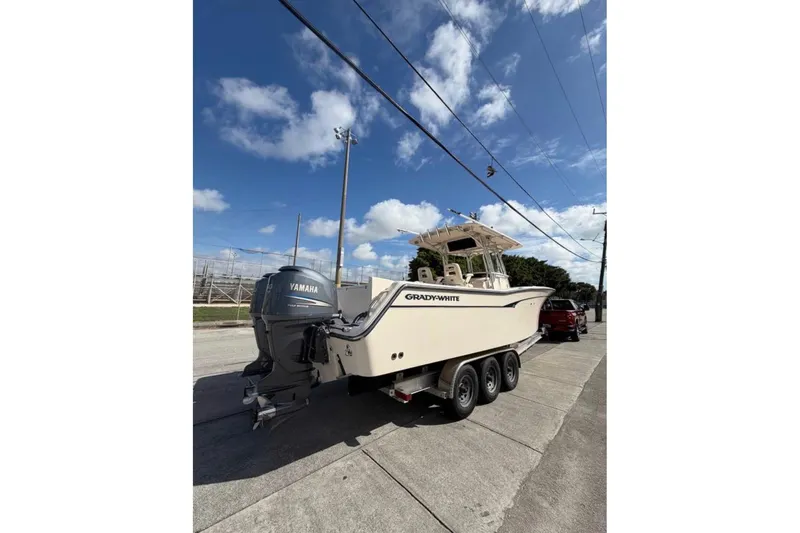  Yacht Photos Pics 2007 Grady-White Bimini 306 boat on trailer, parked on street under blue sky.