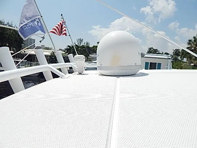 Intrepidation Yacht Photos Pics 2009 Intrepid 430 Sport Yacht deck with radar dome and flags under clear sky.
