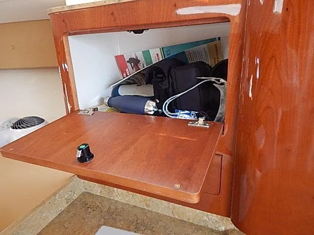 Intrepidation Yacht Photos Pics Open wooden cabinet on 2009 Intrepid 430 Sport Yacht, storing various items.