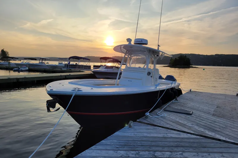  Yacht Photos Pics 2015 Regulator 28 Forward Seating boat docked at sunset on a serene lake.