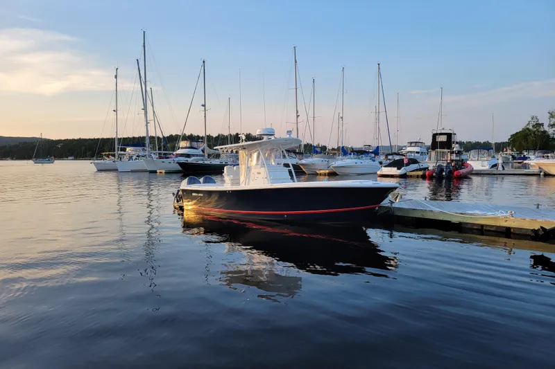  Yacht Photos Pics 2015 Regulator 28 Forward Seating boat docked in a serene marina at sunset.