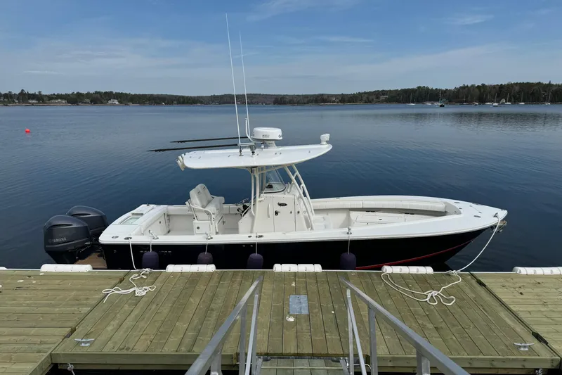  Yacht Photos Pics 2015 Regulator 28 Forward Seating boat docked on calm lake.