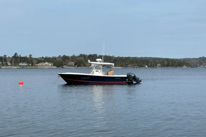  Yacht Photos Pics 2015 Regulator 28 Forward Seating boat anchored on calm lake with distant shoreline.