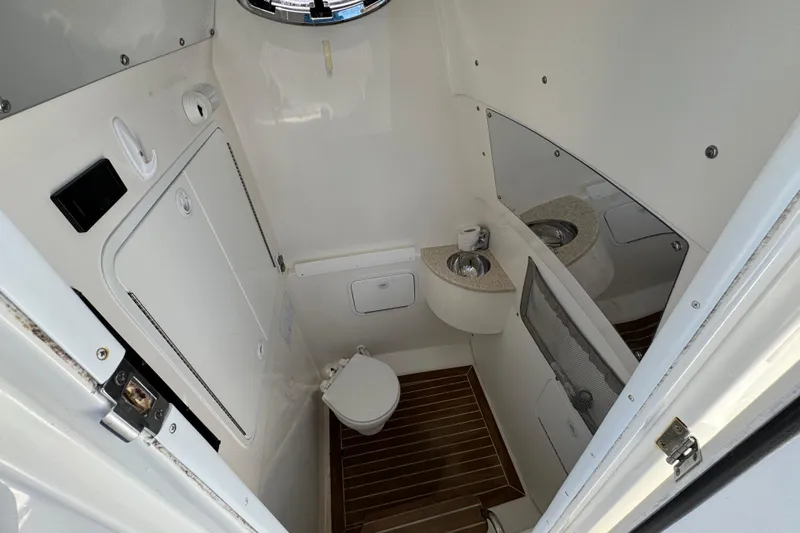  Yacht Photos Pics 2015 Regulator 28 Forward Seating boat interior with compact bathroom and wooden flooring.