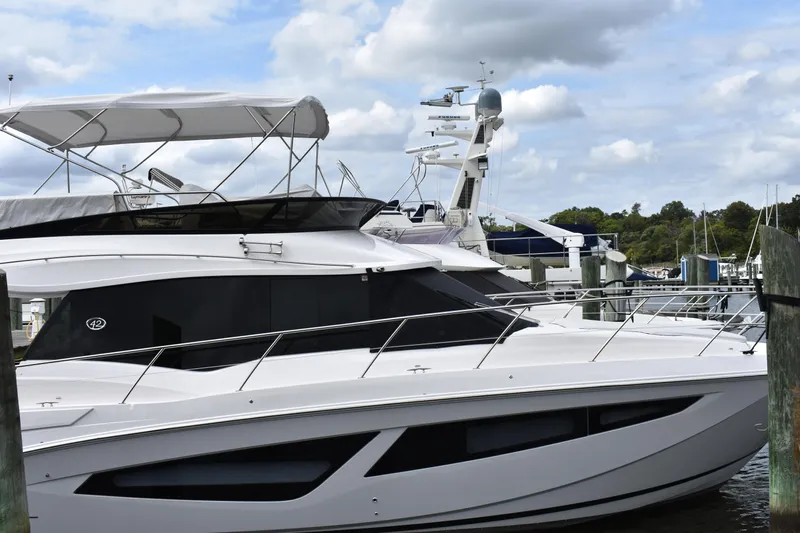 Me Yacht Photos Pics 2021 Regal 42 Fly yacht docked at marina under cloudy sky.