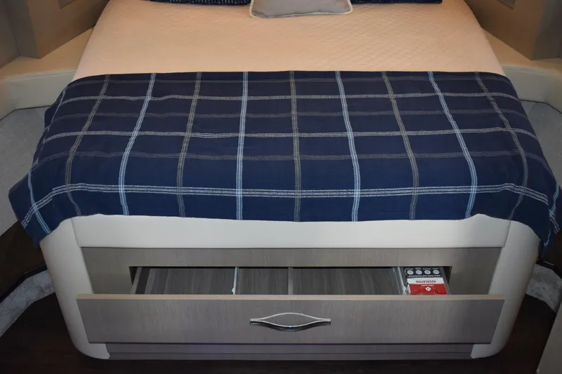 Me Yacht Photos Pics Bed with blue checkered blanket and storage drawer in 2021 Regal 42 Fly yacht.