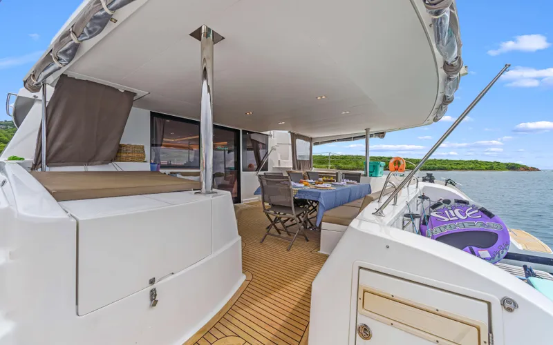 Wonderlust Yacht Photos Pics Luxurious 2016 Fountaine Pajot 72 yacht deck with seating, dining area, and scenic water view.
