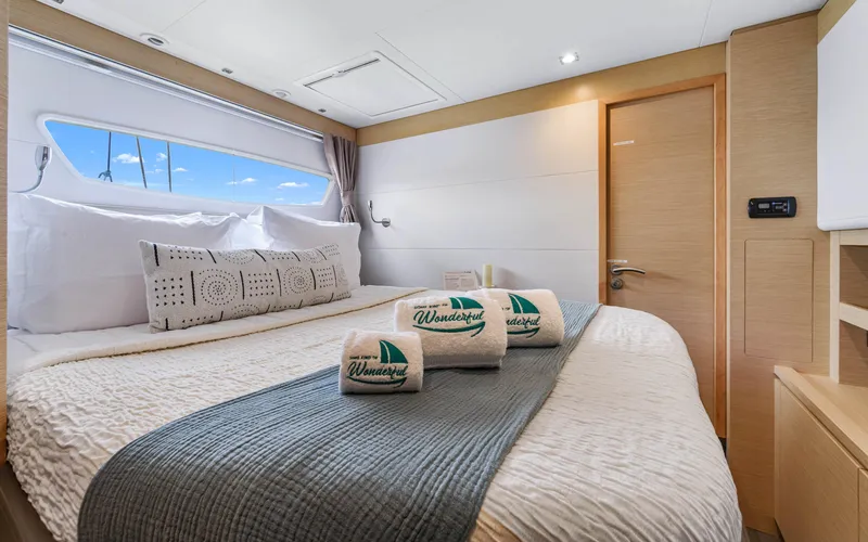 Wonderlust Yacht Photos Pics Luxurious cabin interior of 2016 Fountaine Pajot 72 yacht with cozy bedding and window view.