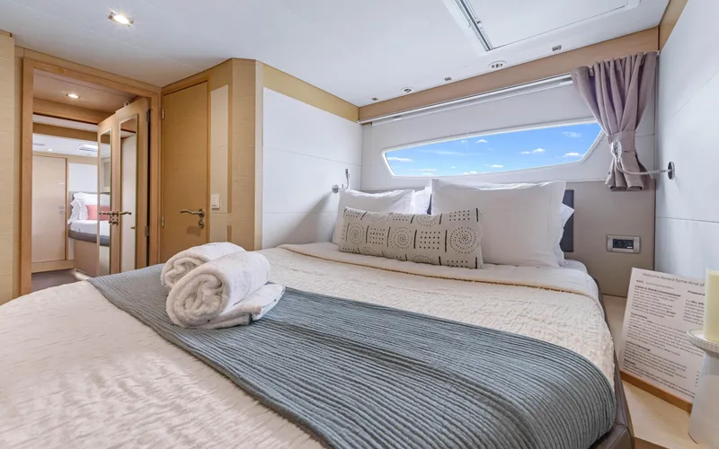 Wonderlust Yacht Photos Pics Luxurious bedroom interior of 2016 Fountaine Pajot 72 yacht with elegant bedding and window view.