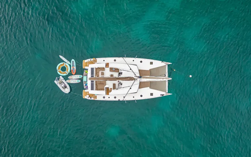 Wonderlust Yacht Photos Pics Aerial view of 2016 Fountaine Pajot 72 catamaran with water toys in turquoise sea.