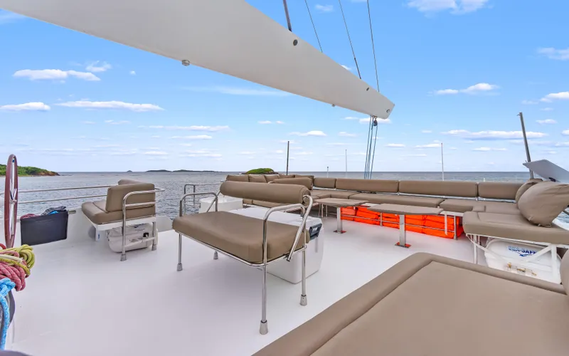 Wonderlust Yacht Photos Pics Spacious deck of 2016 Fountaine Pajot 72 catamaran with seating, ocean view, and clear sky.