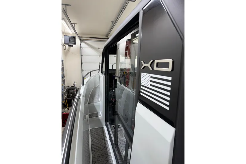 Dfndr1 Yacht Photos Pics 2021 XO Boats DFNDR 9 side view in a garage, showcasing sleek design and logo.