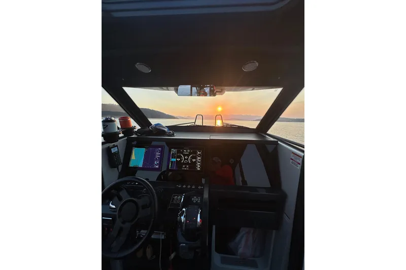 Dfndr1 Yacht Photos Pics Cockpit view of 2021 XO Boats DFNDR9 at sunset, featuring navigation screens and steering wheel.