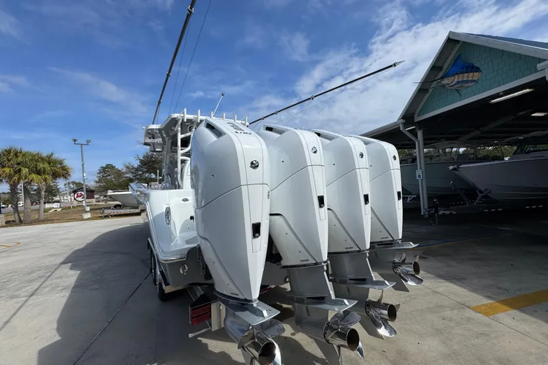  Yacht Photos Pics 2026 Invincible 43 Open Fisherman with four powerful outboard engines, docked under a clear sky.